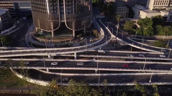 Aerial shot of motorway with cars passing at base of building along Brisbane River, Queensland alt