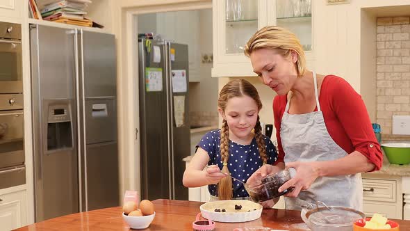 Playful mother and daughter putting berries over dough 4K 4k alt
