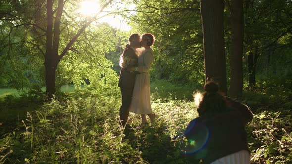 Professional Photographer Takes Pictures of Beautiful Loving Couple of Husband and Wife at Sunset alt