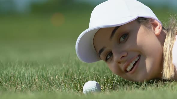 Mischief Girl Hitting Golf Ball Into Hole With Fingers, Having Fun, Close-Up alt