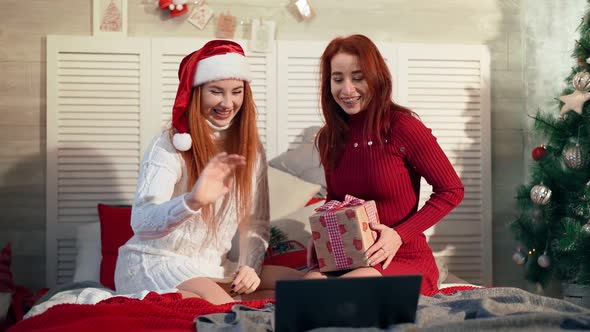 Two Playful Women Chatting Happy New Year Friends Online Via Laptop. Christmas alt