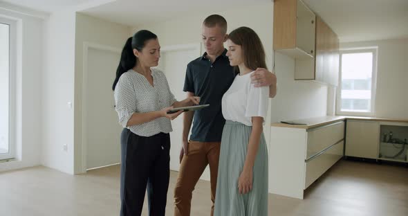 Estate Agent Showing Couple New Apartment and Using Digital Tablet