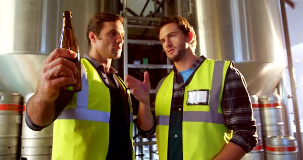 Two brewers checking beer bottles 4k alt