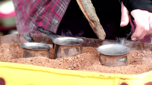 Preparation Of Turkish Coffee In The Turks On The Hot Sand On The Street alt