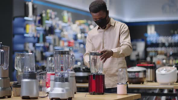 Young Man is Shopping in Kitchen Appliances Store During Pandemic of Covid19 Shopper with Face Mask alt