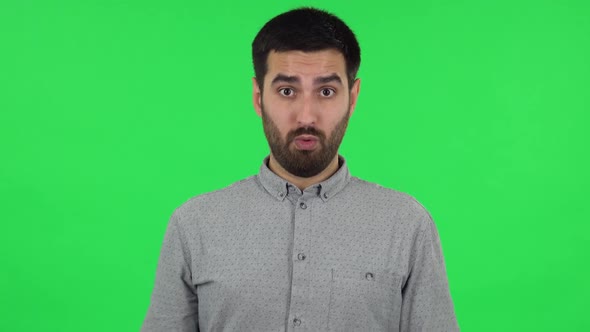 Portrait of Brunette Guy Is Waving His Hands in Indignation, Shrugs. Green Screen alt