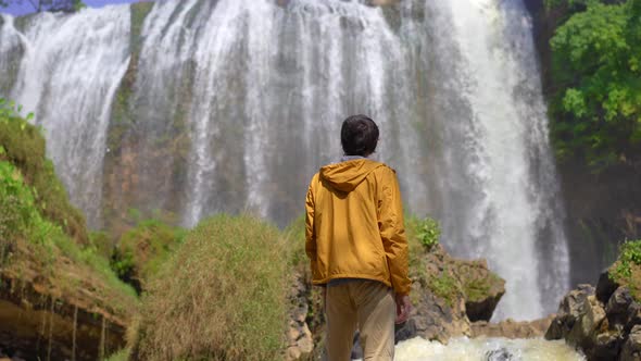 Man Tourist Visits the Elephant Waterfall in the City of Dalat in the Southern Part of Vietnam alt
