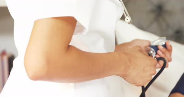 Female doctor measuring blood pressure of mature woman in bedroom 4k alt