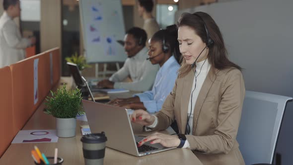 Woman Looking Stressed Out While Working on Laptop in Office alt