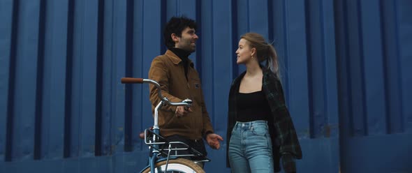 Young woman and man have conversation while wind blows their hair alt