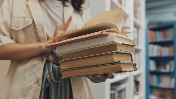 Midsection of Student Turning Book Pages while Reading alt