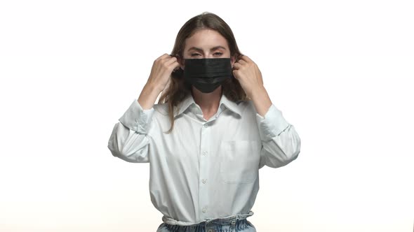 Video of Attractive Brunette Woman in White Shirt Takingoff Black Medical Mask Inhaling Air and alt