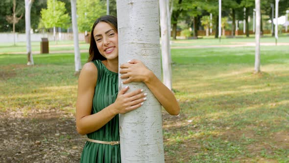 Woman hugging tree in park alt