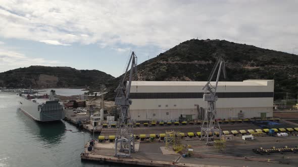 Cranes on quay of Cartagena industrial port, Spain. Aerial orbiting