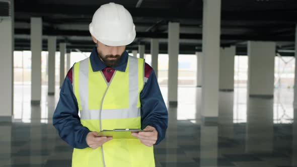 Portrait of HSE Inspector Checking Industrial Zone Reading Papers Indoors alt