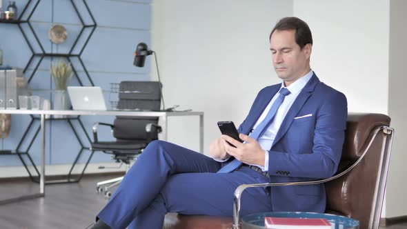 Happy Businessman Excited for Success Using Smartphone alt