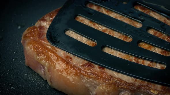 Beef Steak Cooking And Pressed With Spatula alt