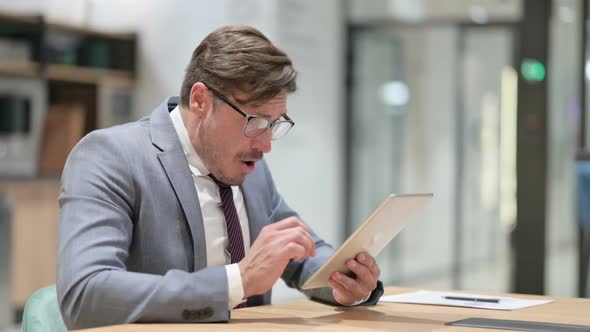 Disappointed Businessman Having Loss on Tablet in Office alt