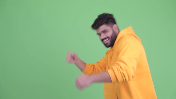 Happy Young Overweight Bearded Indian Man Touching Something and Dancing alt
