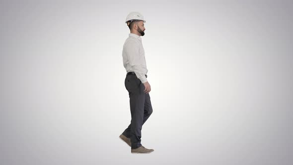 Businessman in Formal Wear and White Hardhat Walking on Gradient Background alt