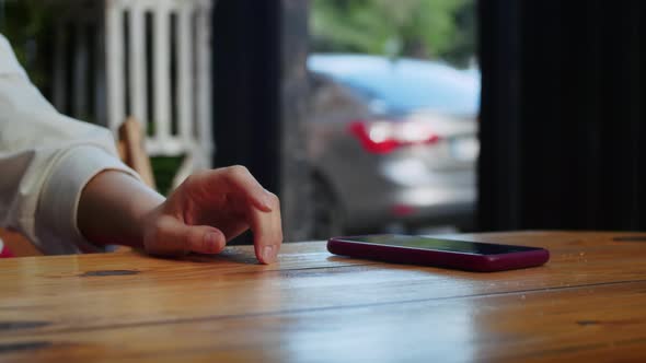 Closeup of the Girl's Hand She Taps Her Fingers on the Table in Anticipation of Another Person alt