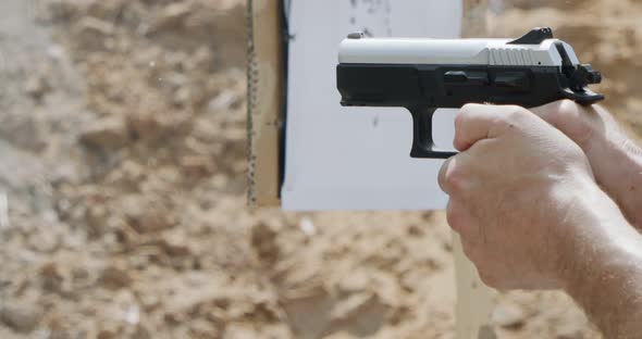 Pistol shooting bullets in slow motion footage. Hand guns in firing range alt