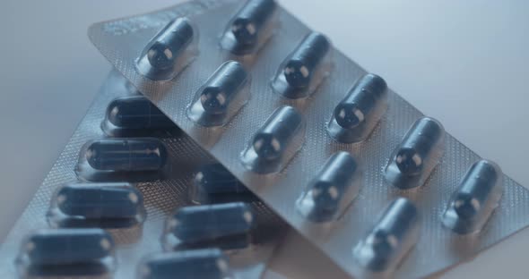 Prescription drugs - Capsules, pills, tablets on reflective background alt