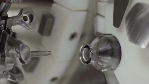 Vertical Video Glass Bottles on a Medical Solution Conveyor at Filling Station Close Up