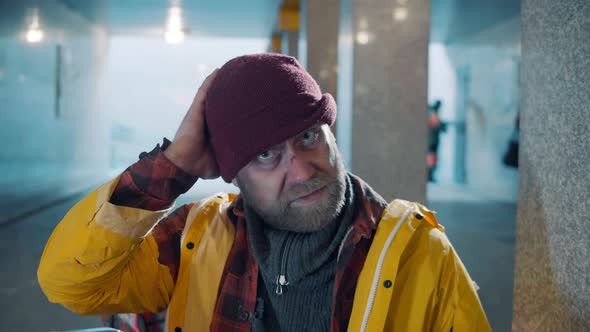 A Homeless Man with a Scratched Face is Looking at the Camera alt