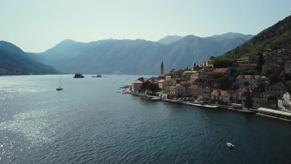 View of city Perast in Montenegro. Flying over the Kotor Bay and mountains alt