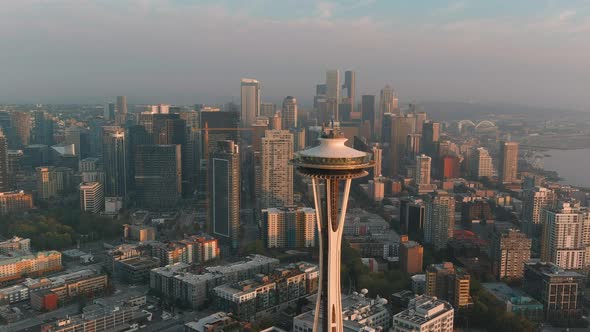 Aerial shot pushing in on the Space Needle during sunset with Seattle's downtown in the background. alt