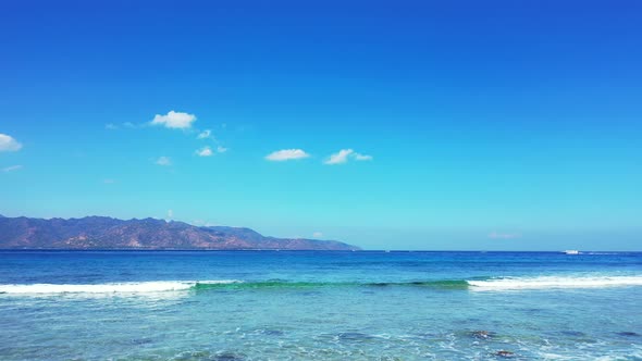Paradise seascape with white waves foaming over rocky seabed on seashore of tropical island with lig alt