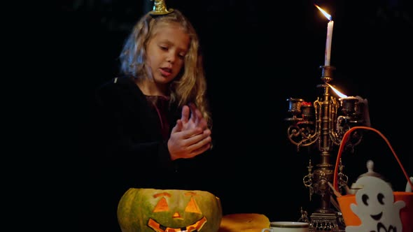 Blurred Caucasian Girl Warming Hands Over Jackolantern Grimacing Making Scary Faces alt