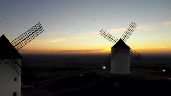 Aerial view of windmills in the countryside in Spain at sunrise alt