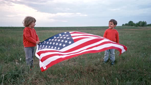 Little Boys  American Patriot Children Stands with National Flag on Open Area Field alt
