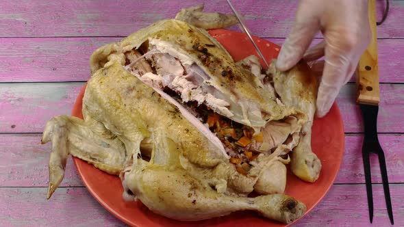 Chefs Hands Cut Boiled Whole Chicken Into Pieces with Knife and Fork on Domestic Kitchen alt