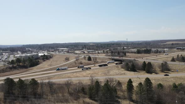 Aerial view of freeway crossroads and bridge in open countryside with hazy blue sky.