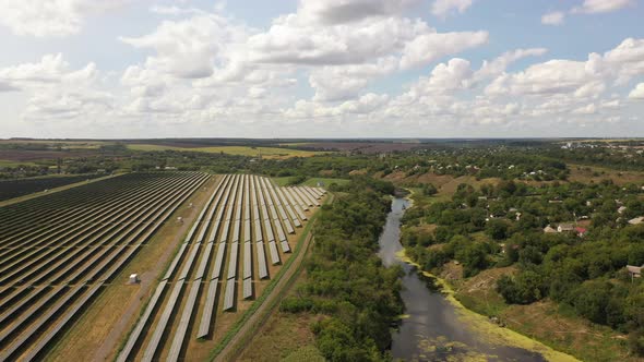 Aerial view of the Solar panels on a hill above the river alt