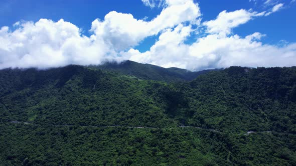 Parallel flight along highway running through dense forest-covered mountain in Eastern Taiwan on a b alt