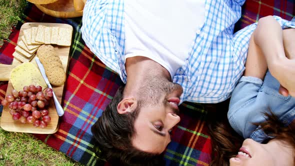 Couple lying on picnic blanket alt