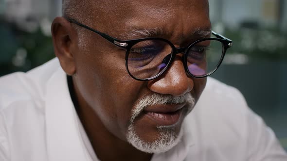 Closeup Shot Of Black Mature Businessman Wearing Eyeglasses Reading On Computer Screen alt