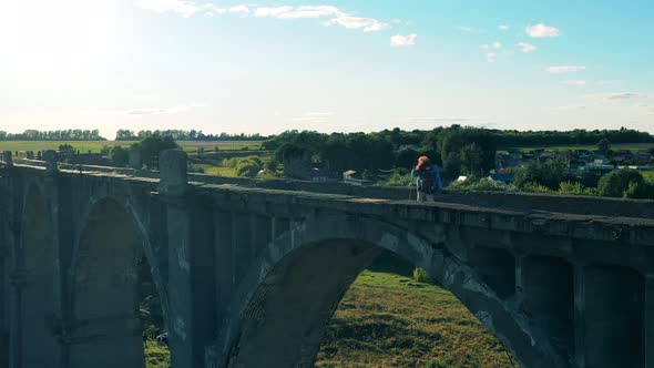Abandoned Bridge Is Being Crossed By a Female Sports Tourist alt