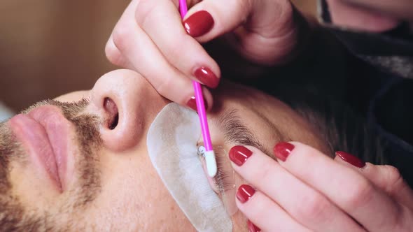 Beautician is Covering Eyelashes of Male Client by Keratin Composition alt