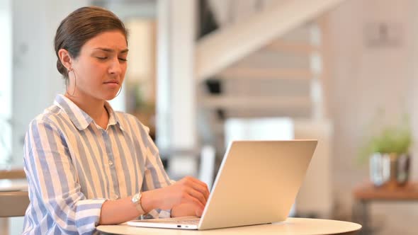 Serious Young Latin Woman Using Tablet at Home alt