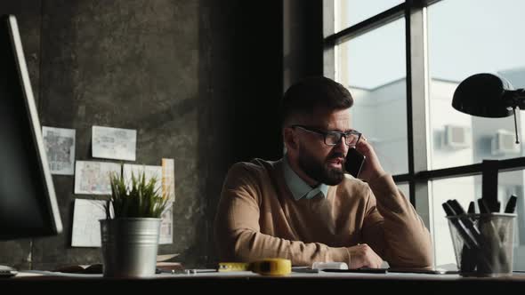 Attractive Man Making Business Conference Call, Talking on Smartphone