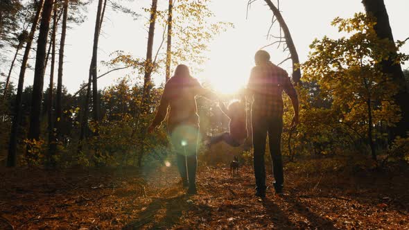 Dad, Mom and Child Are Walking in the Forest alt