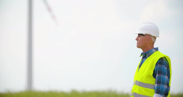 Engineer with Blueprint Analyzing Farm Against Sky alt