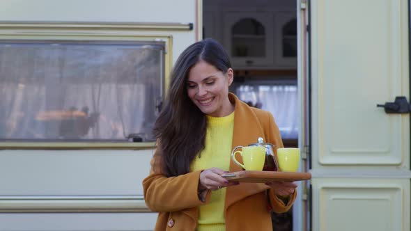 Female Brings Hot Tea To Own with Male Male in Arms Sitting at Table While Walking in Park with alt