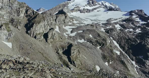 View of Rocky and Snowy Mountain Peak, Rocks on the Floor and Blue Sky at the Back of Mountain Range alt