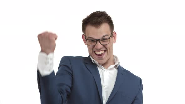 Successful Happy Businessman in Blue Suit and Glasses Rejoicing Shouting for Joy and Victory Saying alt